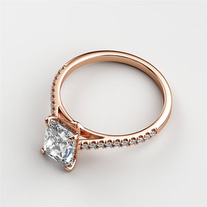 Elegant princess-cut diamond engagement ring in 14K rose gold, featuring a radiant solitaire diamond and a delicate pave band.