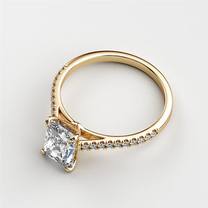 Elegant 14K yellow gold engagement ring featuring a cushion-cut diamond and pave-set band, perfect for a luxurious statement.