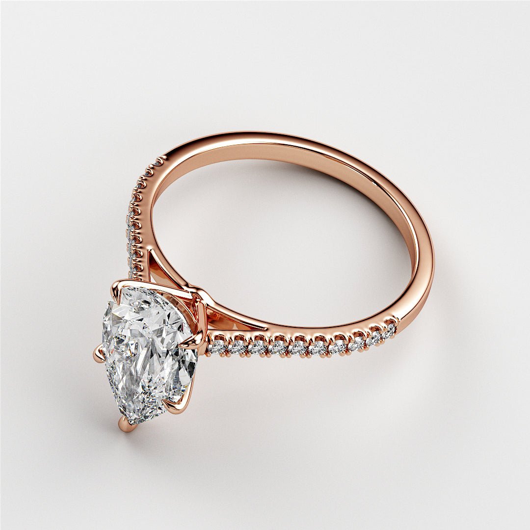 Rose gold engagement ring featuring a pear-shaped diamond and a diamond-encrusted band, available in 14K, 18K, or platinum.