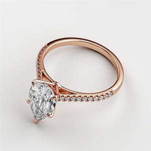 Rose gold engagement ring featuring a pear-shaped diamond and a diamond-encrusted band, available in 14K, 18K, or platinum.