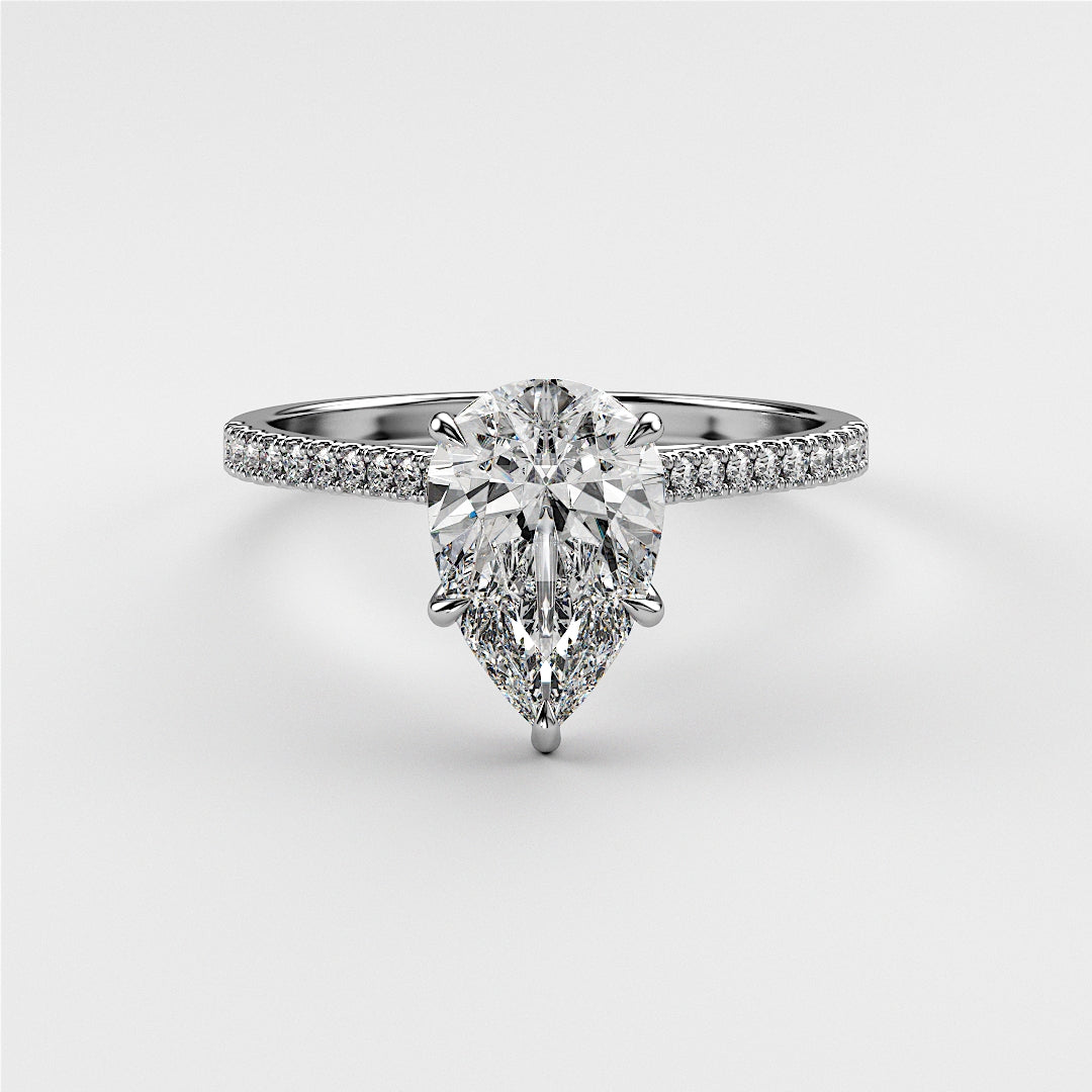 Elegant pear-shaped diamond solitaire engagement ring in 14K or 18K white gold, accented with pave diamonds in a cathedral setting.