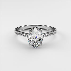 Elegant 14K white gold engagement ring featuring a stunning oval diamond center stone and delicate pave diamond band.