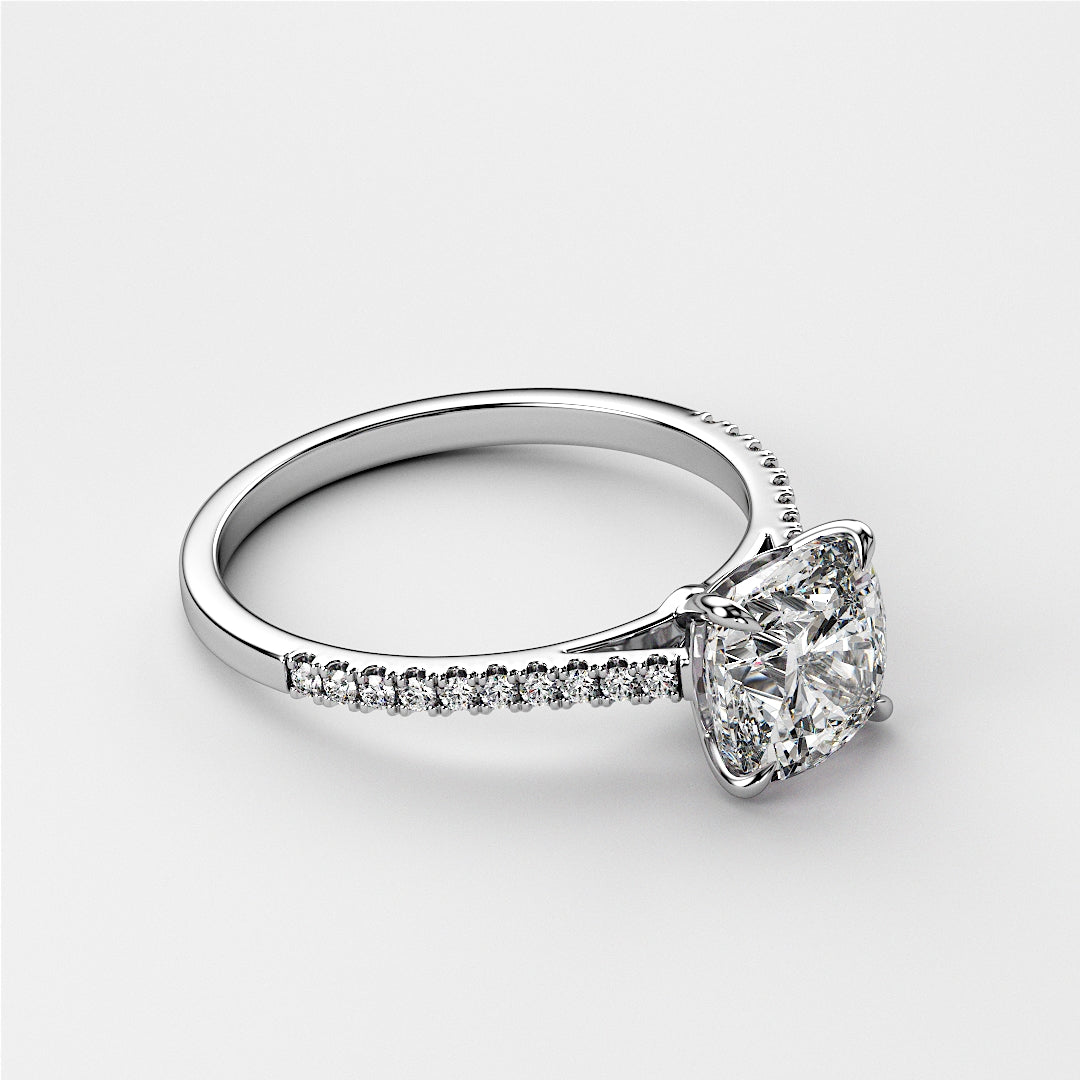 Elegant white gold cushion cut diamond engagement ring withPave band, available in 14K, 18K, or platinum. Gray background.