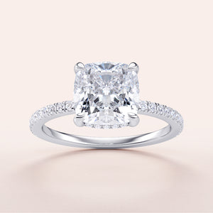 Cushion cut diamond engagement ring in 14K, 18K white gold or platinum, featuring a dazzling pave band and a stunning halo design.