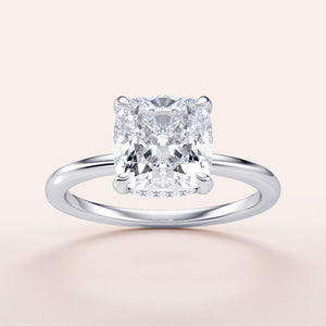 Cushion-cut diamond engagement ring in 14K or 18K white gold, featuring a hidden halo and plain band design.