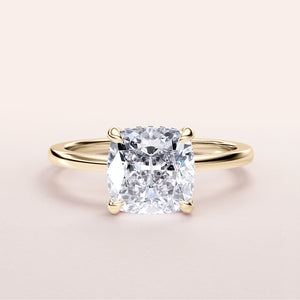 Elegant cushion-cut diamond engagement ring in a sleek 14K gold band, displayed on a neutral background.