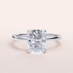 Elegant radiant-cut diamond engagement ring in 14K or 18K white gold, featuring a simple band and hidden halo design.