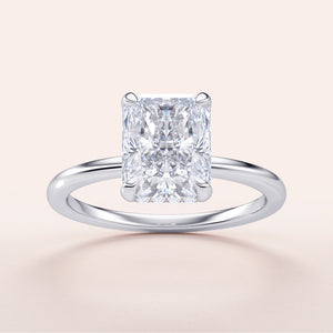 "Radiant cut diamond solitaire ring in 14K white gold, featuring a hidden halo and plain band, perfect for elegant engagements."