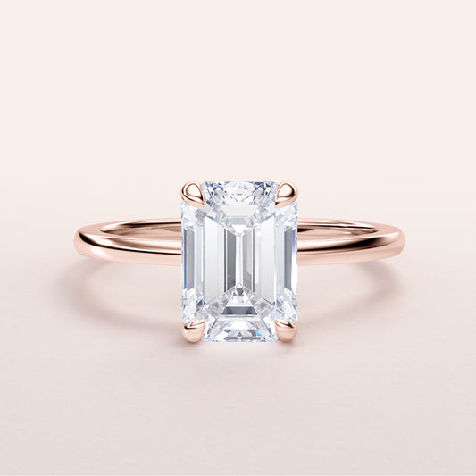 Elegant rose gold emerald cut diamond solitaire ring in 14K or 18K, featuring a hidden halo and a minimalist design.