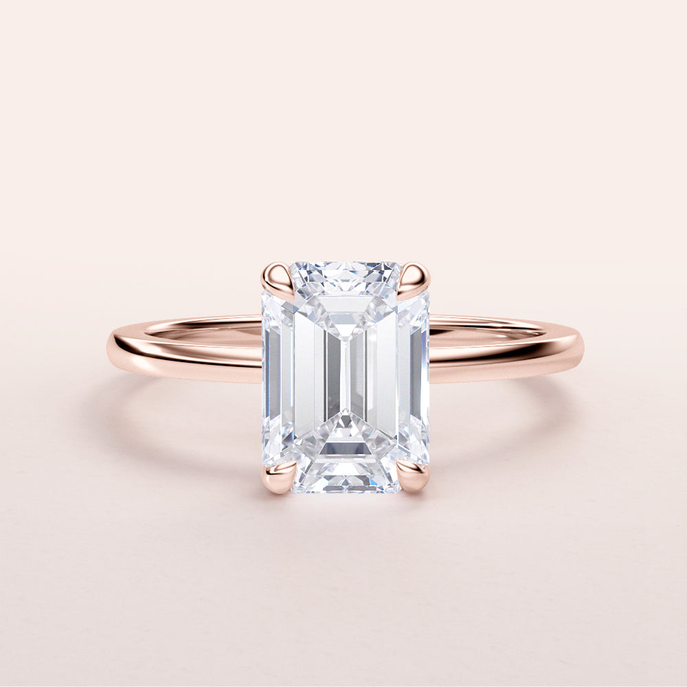 Elegant rose gold emerald cut diamond solitaire ring in 14K or 18K, featuring a hidden halo and a minimalist design.