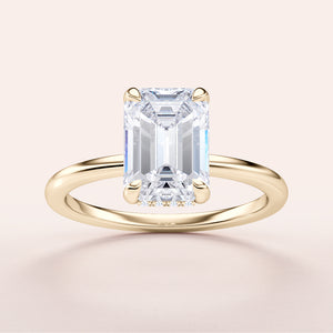 Elegant yellow gold emerald-cut diamond engagement ring, available in 14K, 18K, or platinum, showcasing timeless beauty.