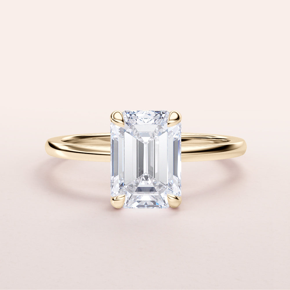 Elegant emerald-cut diamond engagement ring with a yellow gold band, available in 14K or 18K options.