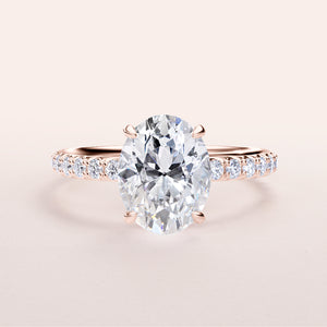 Elegant 14K Rose Gold oval engagement ring with hidden halo, prong accents, and a pave diamond band for timeless beauty.