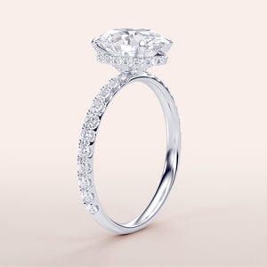 Radiant 14K or 18K white gold engagement ring featuring an oval diamond with hidden halo and pave band accents.