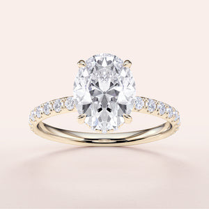 14K yellow gold engagement ring featuring an oval diamond center stone and diamond-accented pave band, on a neutral background.