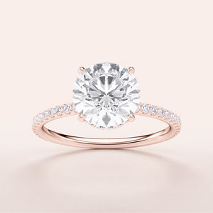 Elegant rose gold engagement ring with round diamond and pave band, available in 14K and 18K options. Timeless luxury.