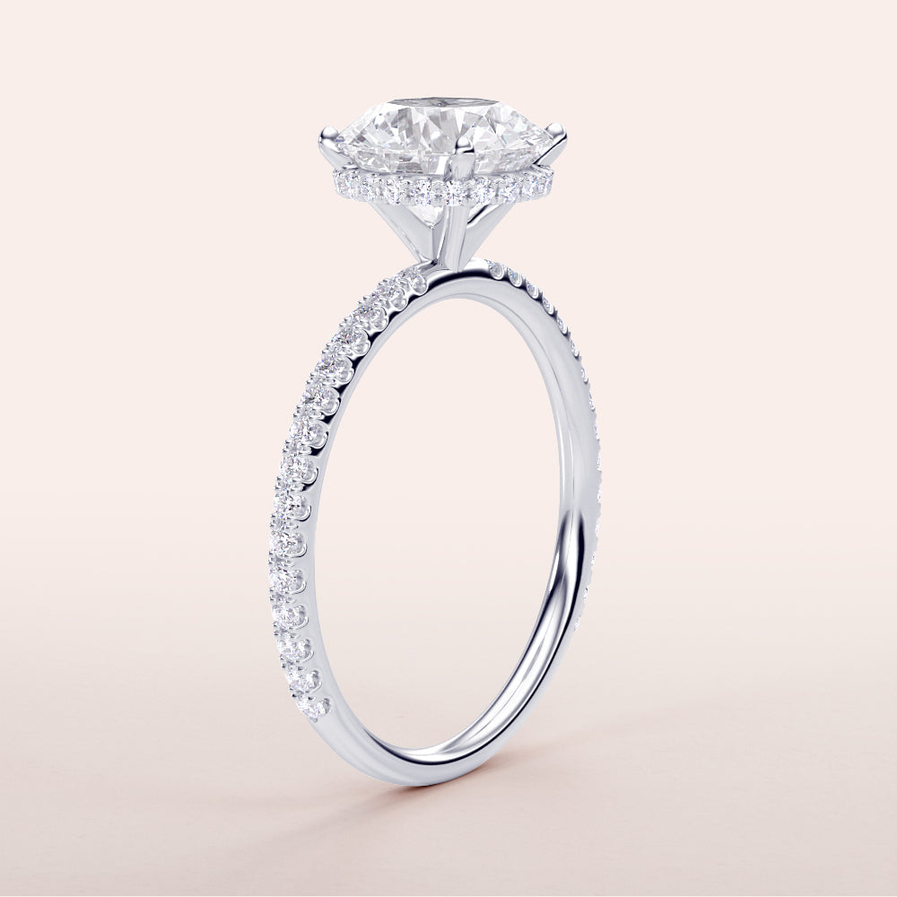 Elegant 14K, 18K, or platinum round wrapped hidden halo pave band engagement ring on a clean background.