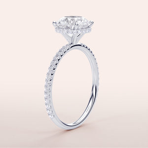 Elegant 14K, 18K, or platinum round wrapped hidden halo pave band engagement ring on a clean background.