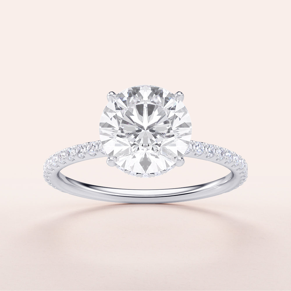 Elegant round brilliant-cut diamond engagement ring with a diamond-studded band in 14K or 18K white gold or platinum.