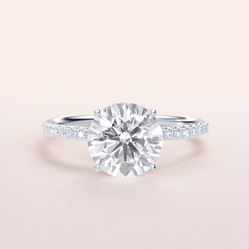 Stunning round diamond engagement ring withPave band in 14K or 18K white gold or platinum, featuring a brilliant round-cut center stone.