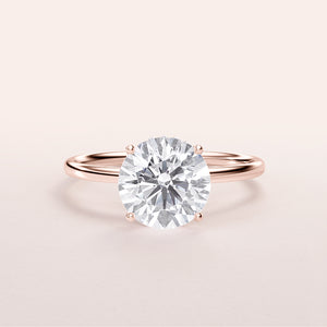 Elegant round diamond solitaire engagement ring in a 14K rose gold band, featuring a stunning hidden halo design.