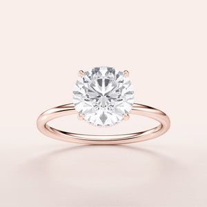 Elegant rose gold 14K wrapped hidden halo engagement ring featuring a round-cut diamond on a sleek plain band.