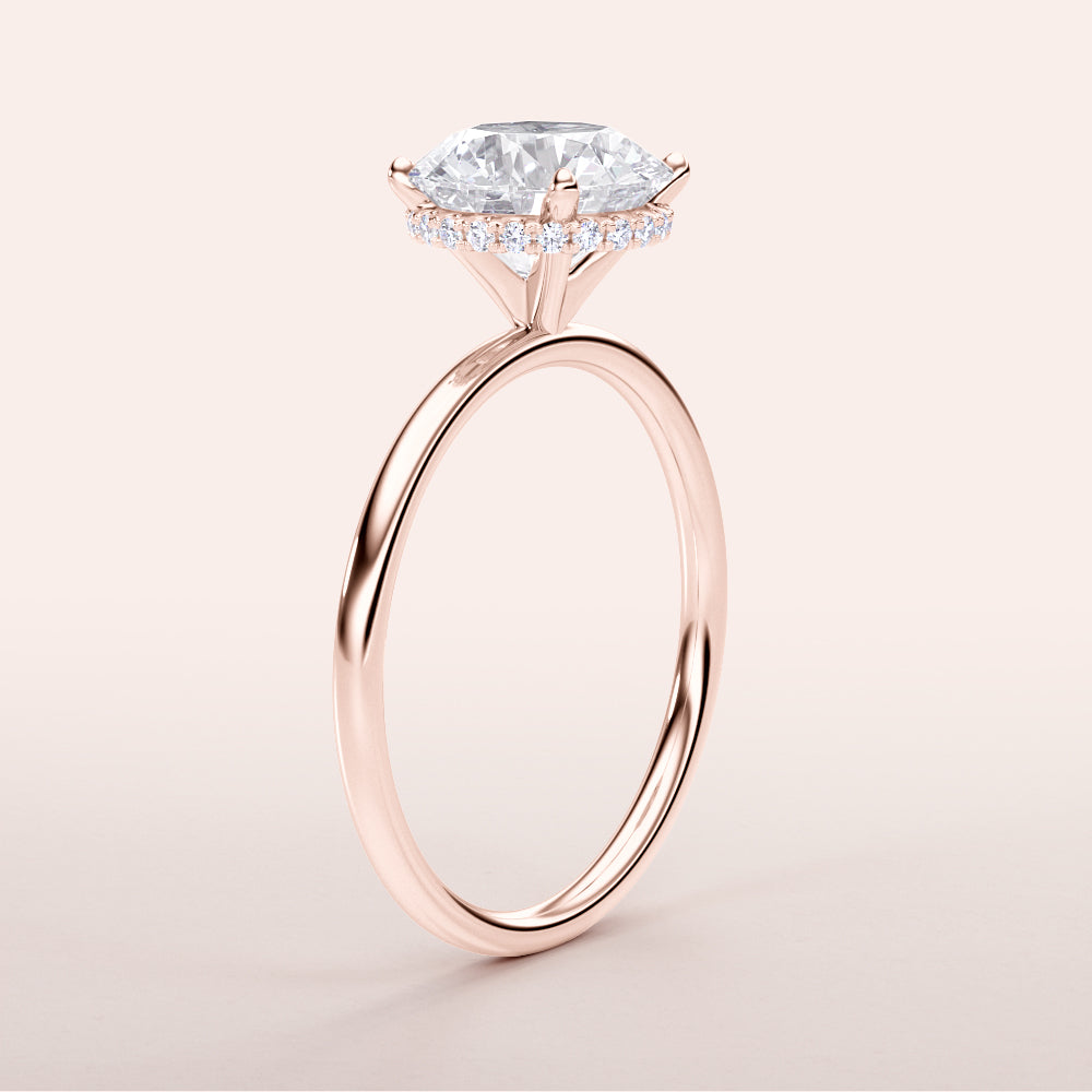 Elegant marquise diamond ring in 14K rose gold with pave diamond halo, close-up view. Also available in 18K and platinum.