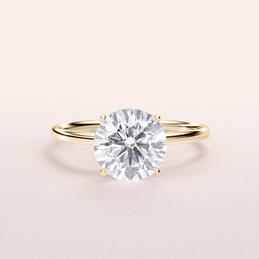 Elegant 14K yellow gold engagement ring featuring a round brilliant-cut diamond in a wrapped hidden halo design.