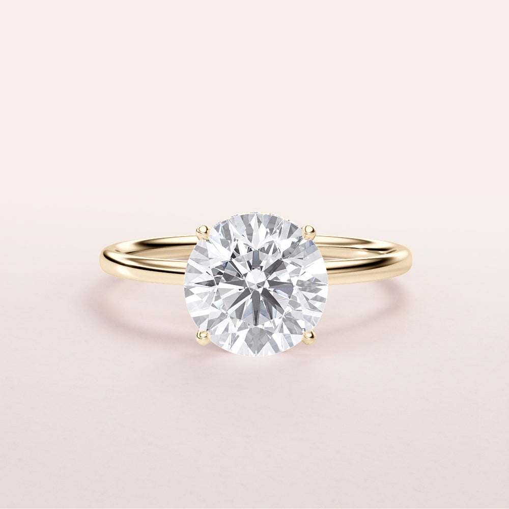 Elegant 14K yellow gold engagement ring featuring a round brilliant-cut diamond in a wrapped hidden halo design.
