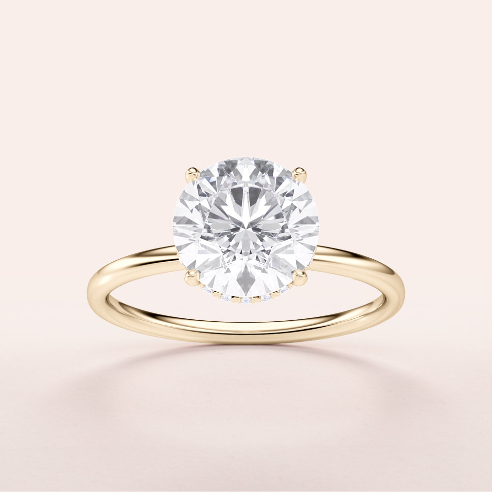 Elegant round-cut diamond solitaire ring in a 14K yellow gold setting, perfect for special occasions. Minimalist design, not worn on a model.
