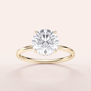 Elegant round-cut diamond solitaire ring in a 14K yellow gold setting, perfect for special occasions. Minimalist design, not worn on a model.