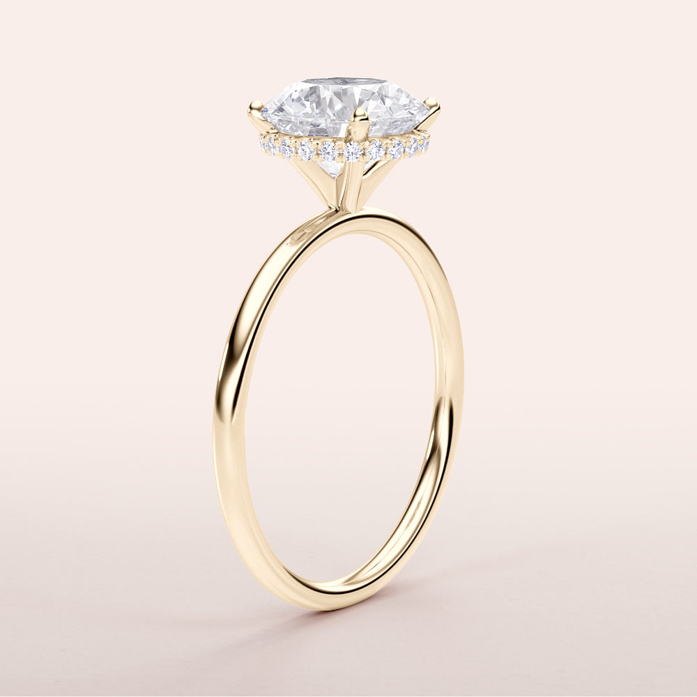 Elegant 14K yellow gold wrapped halo engagement ring with a marquise diamond centerpiece and small diamond accents.