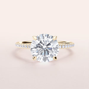 Elegant yellow gold engagement ring with round brilliant-cut diamond and smaller diamonds, available in 14K and 18K options.