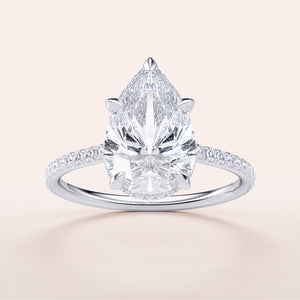 Elegant pear-shaped diamond engagement ring in 14K or 18K gold or platinum, featuring a hidden halo and pave band design.