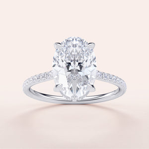 "Elegant 14K or 18K white gold engagement ring with oval diamond center, featuring an invisible gallery and sparkling pave band."