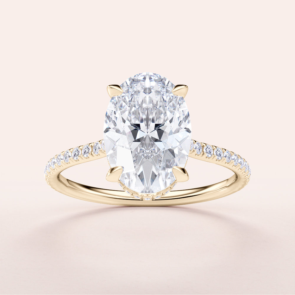 Elegant 14K yellow gold engagement ring with an oval diamond centerpiece and pave band, not worn on a model.