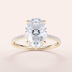 Elegant 14K yellow gold engagement ring with an oval diamond centerpiece and pave band, not worn on a model.