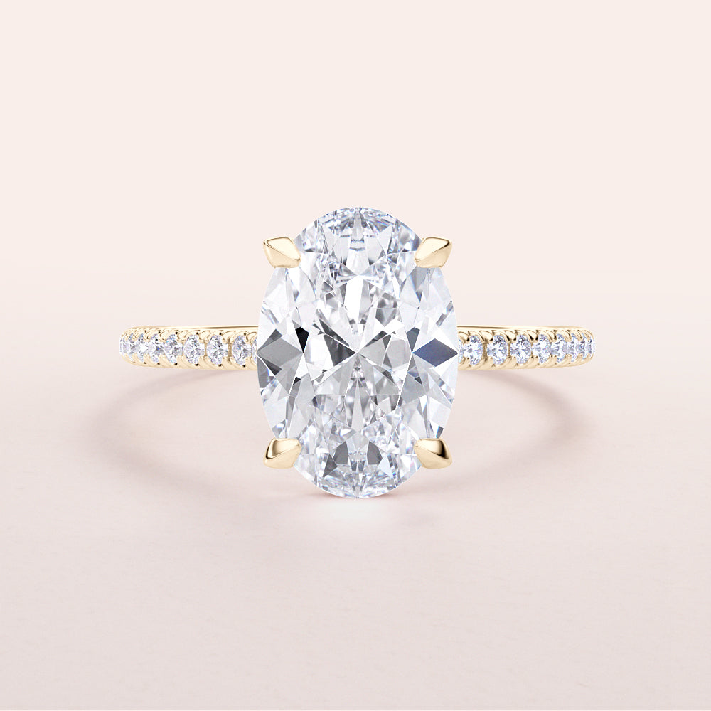 Elegant 14K yellow gold engagement ring with oval-cut diamond center and pave band, perfect for special moments.