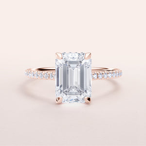 Elegant emerald-cut diamond engagement ring in rose gold, adorned with smaller diamonds. Available in 14K, 18K, and platinum.

#14KRecycledRoseGold
#18KRecycledRoseGold