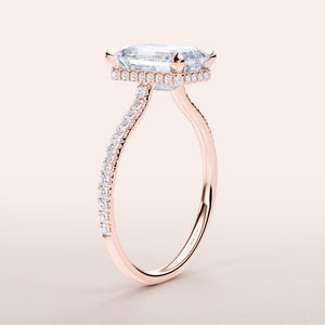 Close-up of a radiant 14K Rose Gold engagement ring featuring an emerald-cut diamond and a pave diamond band.