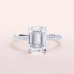 Emerald-cut diamond engagement ring in 14K/18K white gold with pave band, featuring an invisible gallery and hidden halo design.