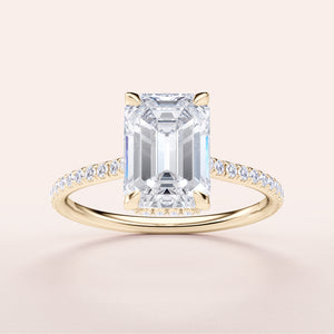 Elegant emerald-cut diamond engagement ring with petite accent diamonds in 14K yellow gold, featuring a unique invisible gallery and hidden halo.