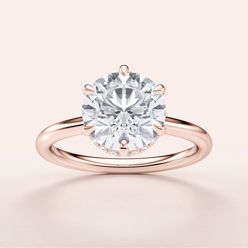 Elegant 14K rose gold engagement ring with a round diamond center, featuring an invisible gallery and a plain band.