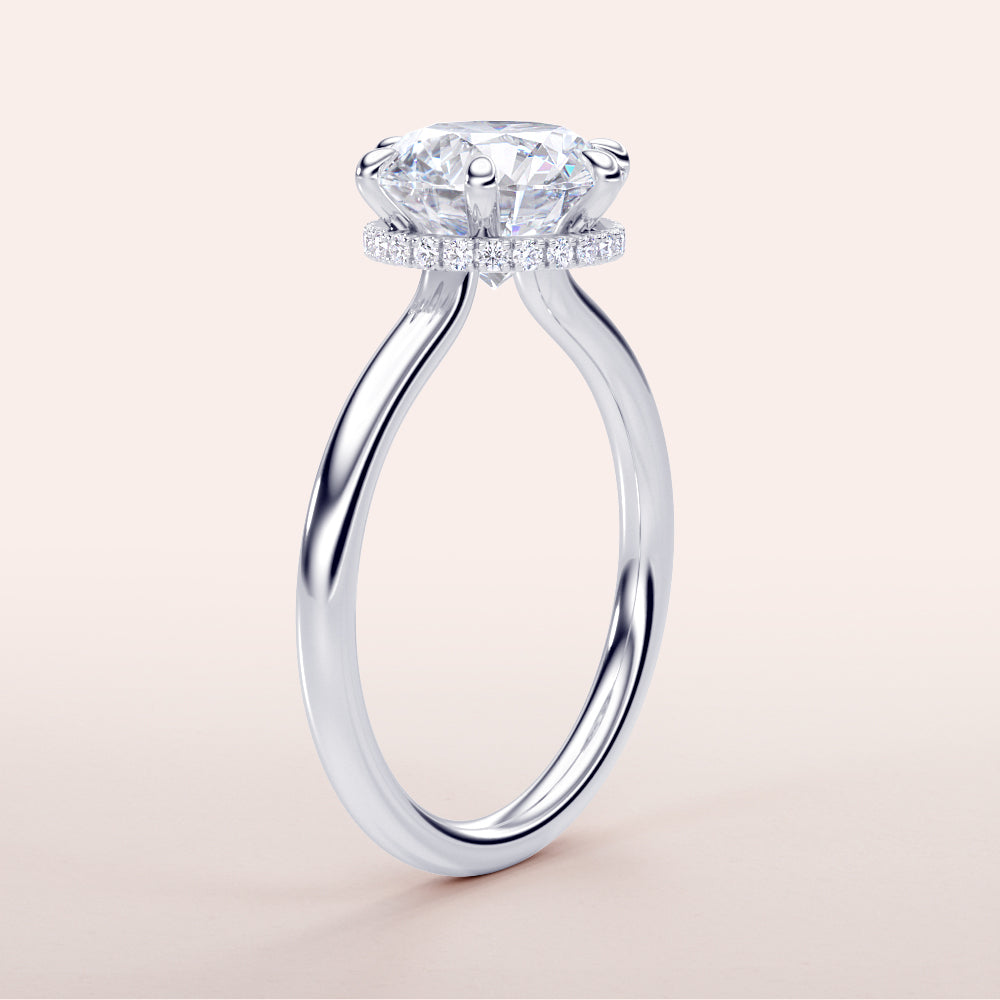 Elegant round engagement ring with hidden halo, featuring a radiant diamond on a sleek band, available in 14K, 18K, or platinum.