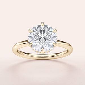 Elegant 14K or 18K yellow gold engagement ring featuring a stunning round brilliant diamond with an invisible halo design.
