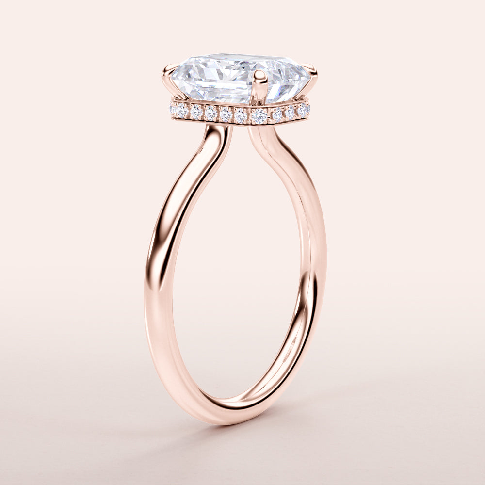 Rose gold engagement ring featuring an elongated cushion-cut diamond with a halo of round diamonds, crafted in 14K or 18K gold or platinum.