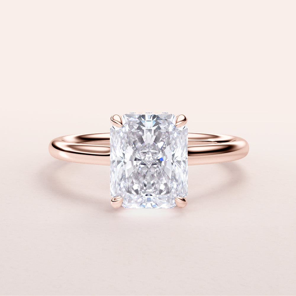 Radiant cut diamond engagement ring in 14K rose gold, showcasing the brilliant gemstone and delicate plain band.