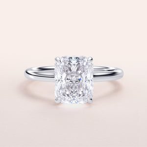 Radiant cut diamond solitaire engagement ring in 14K white gold, showcasing a sleek band against a neutral background.