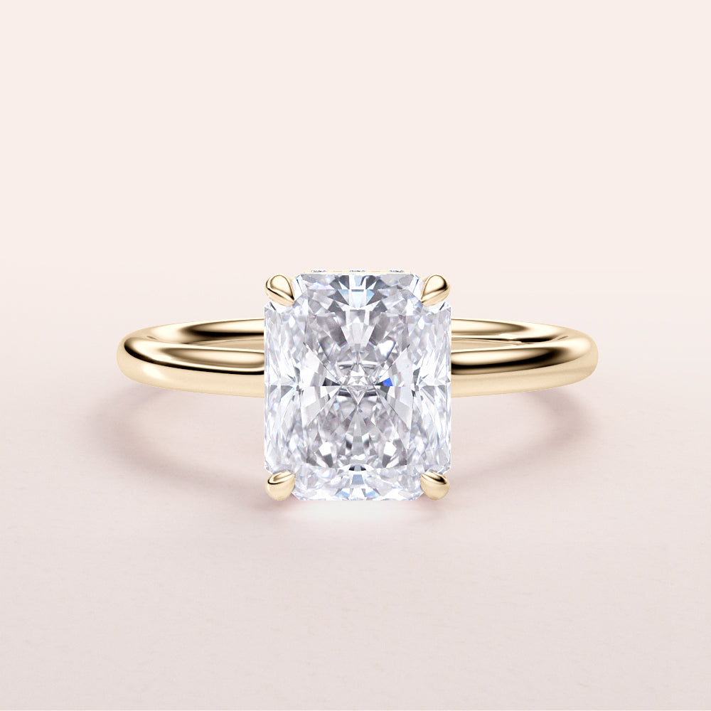 Radiant cut diamond engagement ring with hidden halo and plain band in 14K or 18K gold or platinum, worn on model.