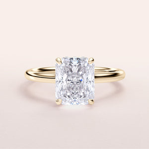 Radiant cut diamond engagement ring with hidden halo and plain band in 14K or 18K gold or platinum, worn on model.